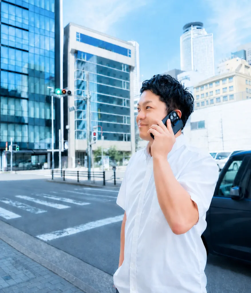 オフィス街で電話をしながら外回りをするメンバー