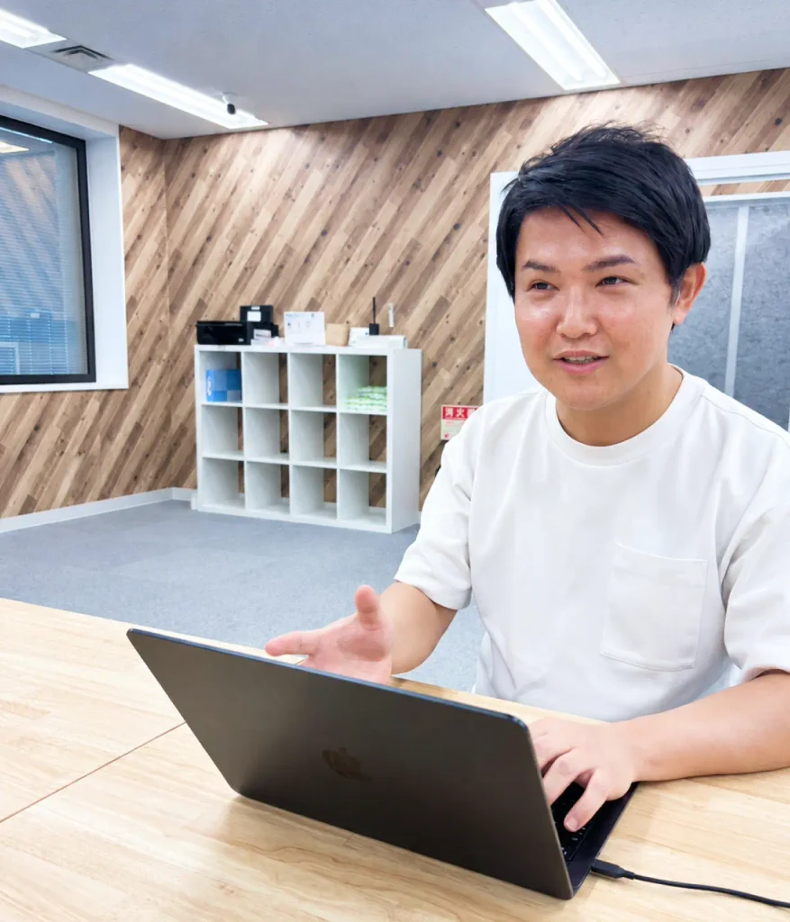 ノートパソコンの前で笑顔で話すメンバー