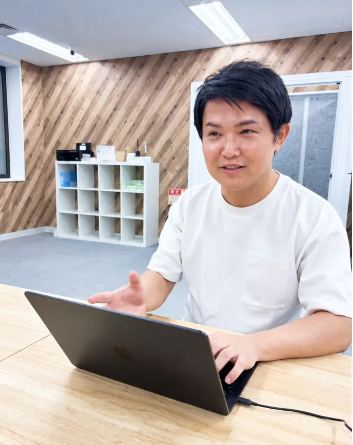 ノートパソコンの前で笑顔で話すメンバー